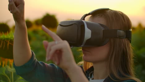 A-girl-farmer-manager-uses-VR-glasses-on-the-field-with-sunflowers-in-sunny-day.-These-are-modern-technologies-in-summer-evening.